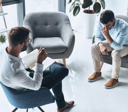 Totally despaired. Top view of young frustrated man solving his mental problems while having therapy session with psychologist