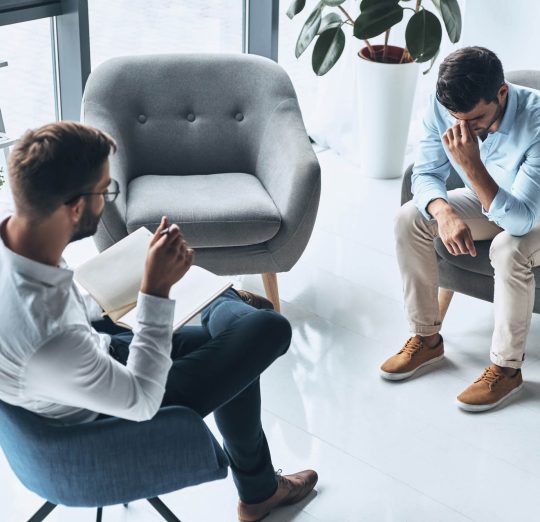 Totally despaired. Top view of young frustrated man solving his mental problems while having therapy session with psychologist